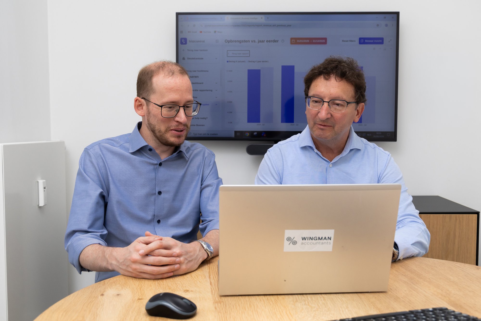 Twee accountants van Wingman Accountants bespreken financiële cijfers aan de vergadertafel